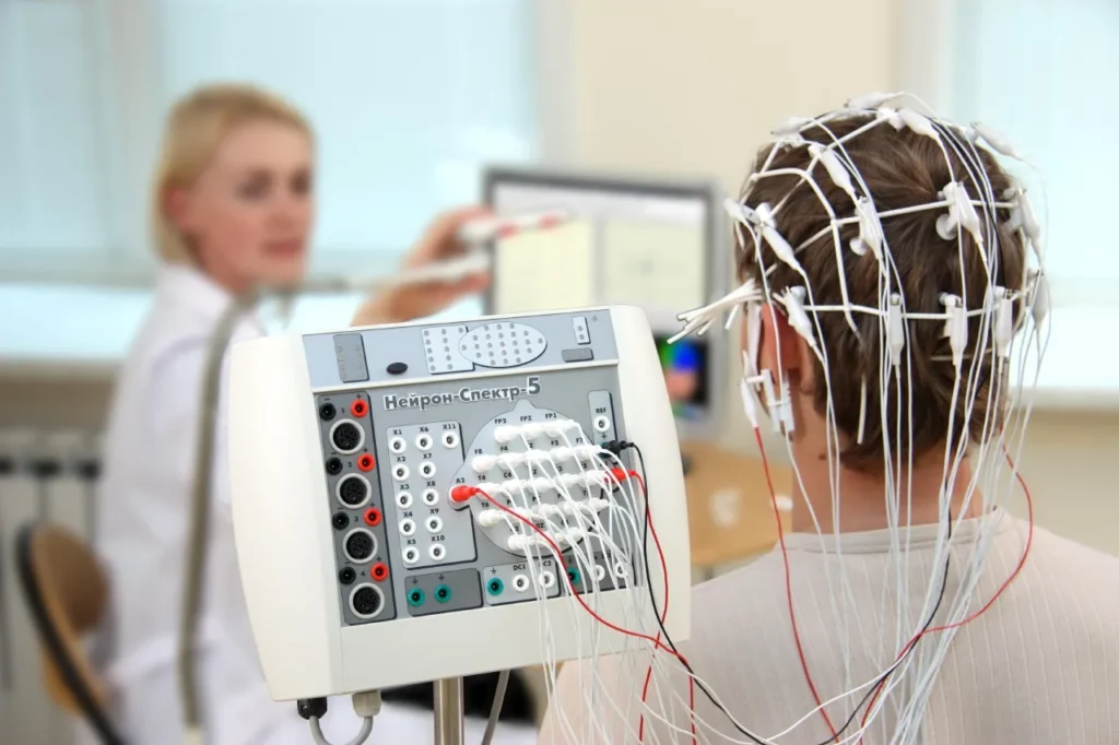 Patient wearing EEG electrodes while a technologist records brain activity